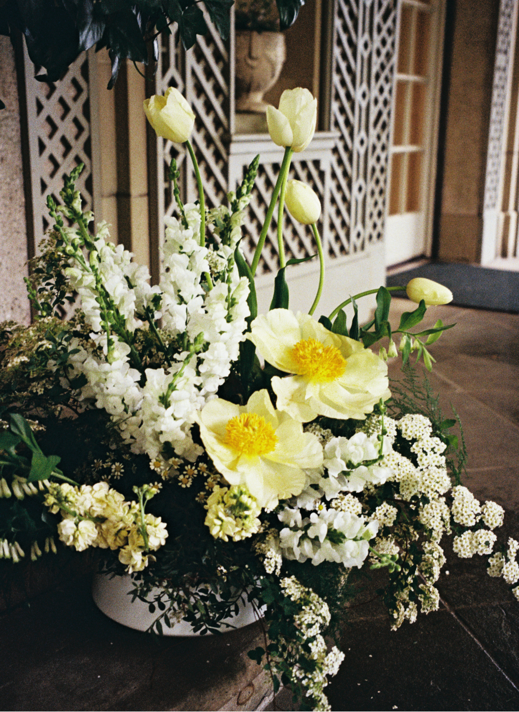 Bouquet of white and yellow flowers in front of a building entrance