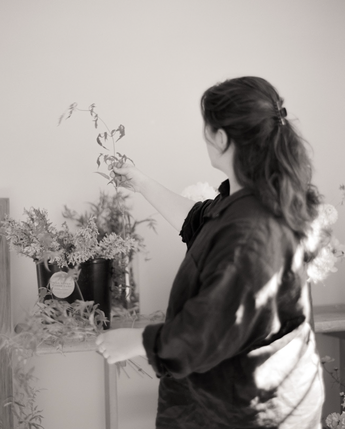 Person arranging flowers in a vase indoors