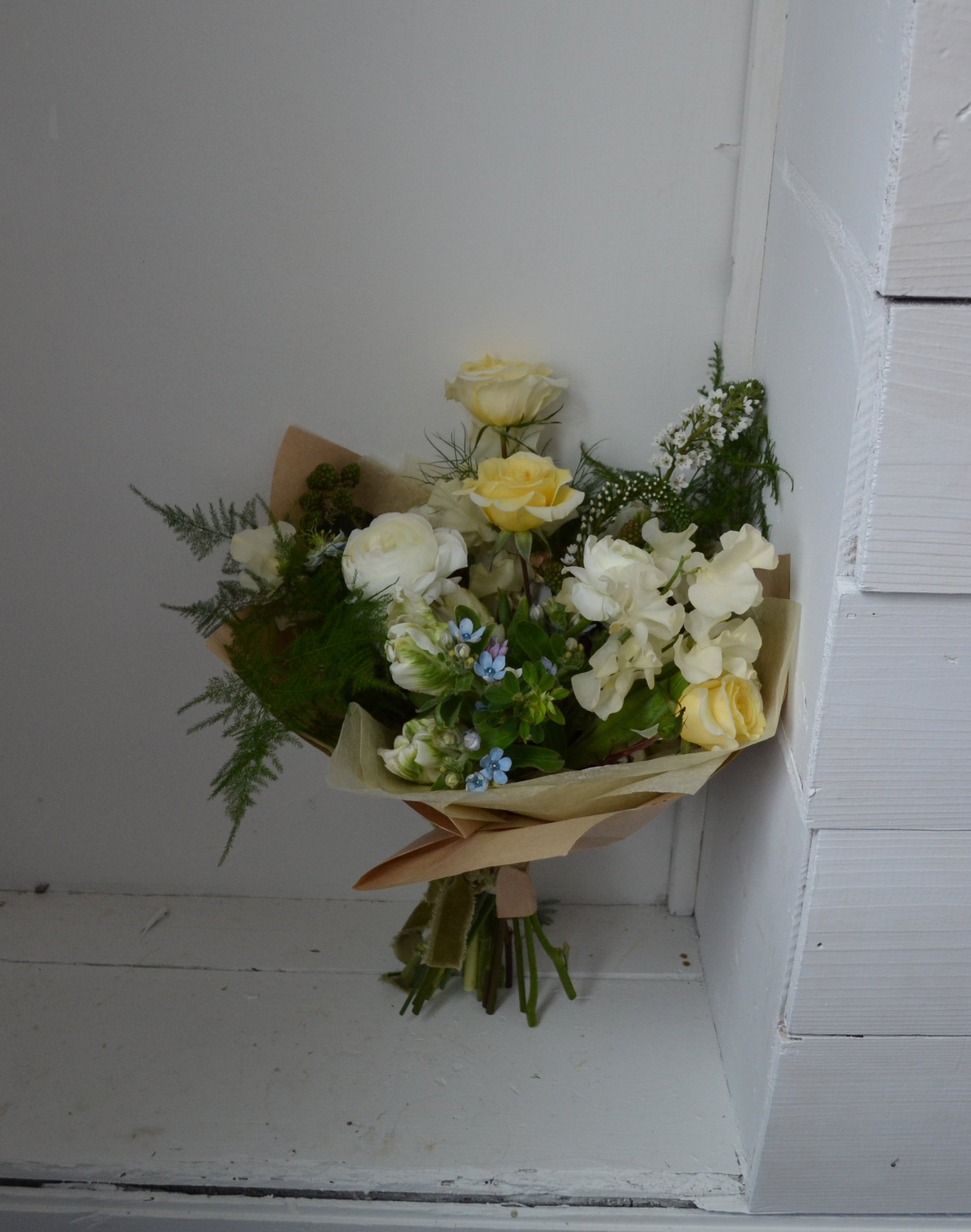 Bouquet of flowers on a white wooden shelf