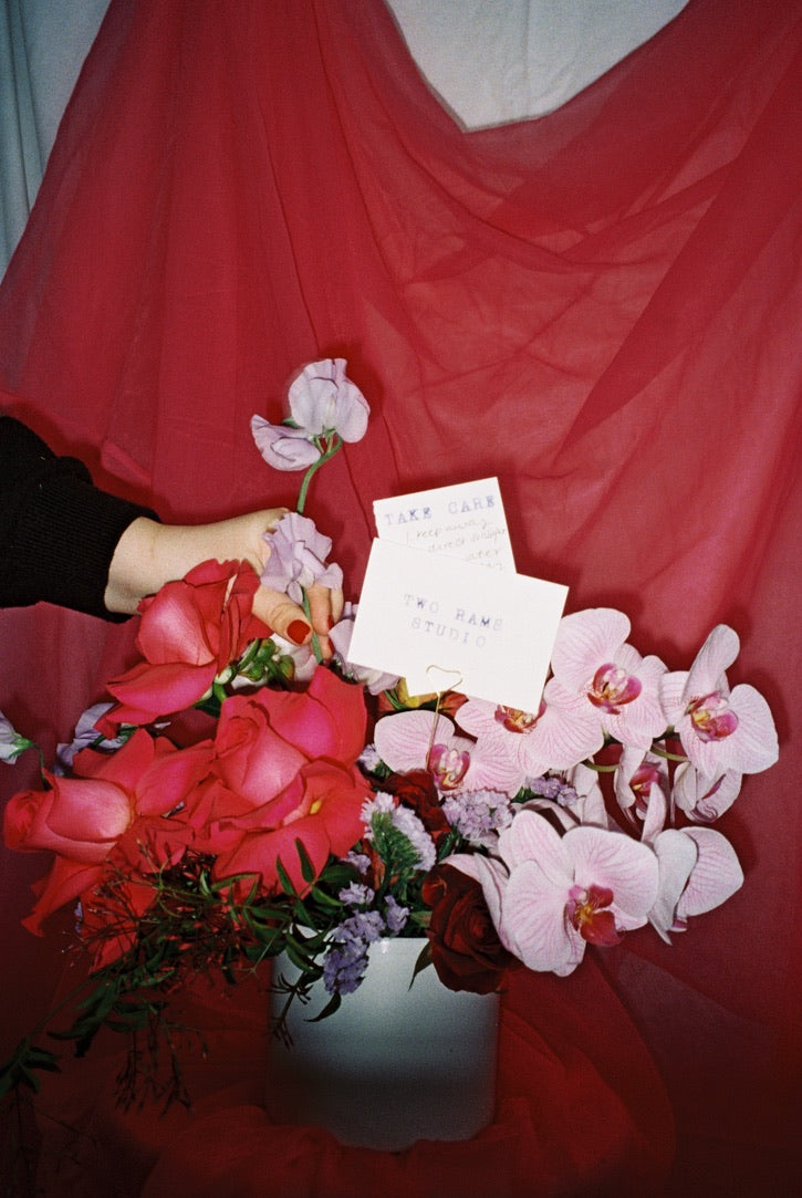 Bouquet of flowers with a letter on a red fabric background